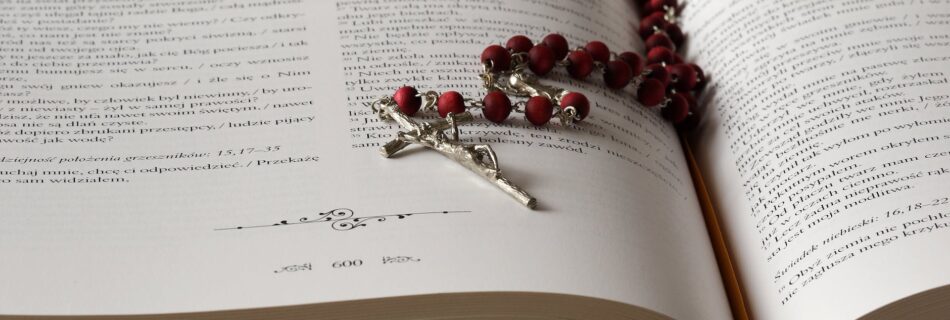 rosary on top of opened bible book