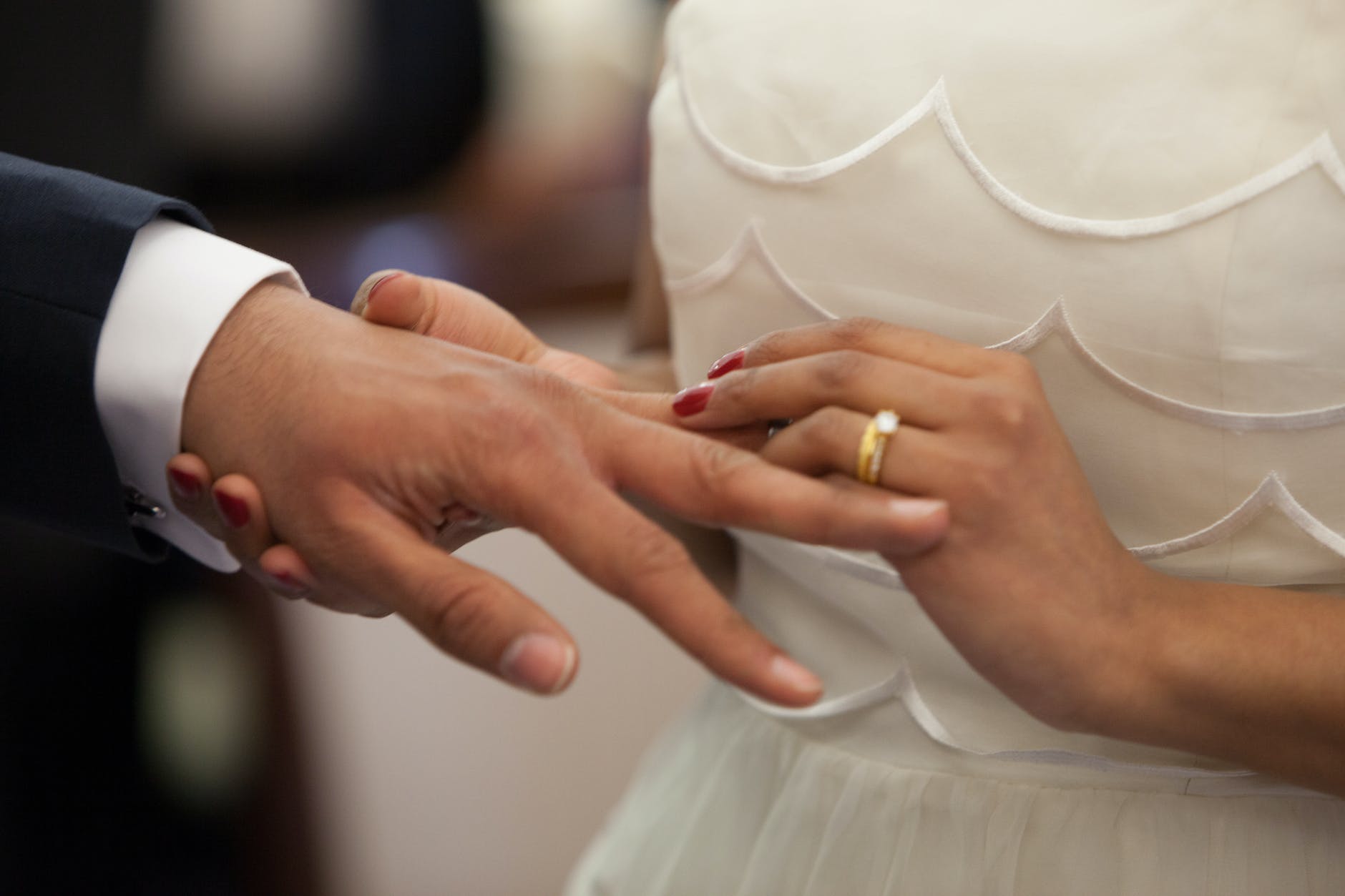 bride putting a ring on grooms hand