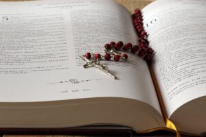 rosary on top of opened bible book